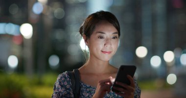 Geceleri kadın cep telefonu kullanıyor.