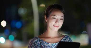 Kadın geceleri tablet bilgisayara bakar.