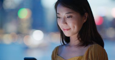 Şehir gece görüşünde kadın cep telefonu kullanımı