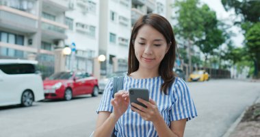 Sokakta akıllı telefon kullanan kadın