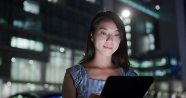 Kadın, akşam vakti dışarıdaki tablet bilgisayara bak.