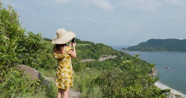 Kadınlar dağda fotoğraf çekmek için cep telefonu kullanırlar.