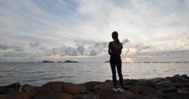 Kadın gün batımı deniz manzarasına bak.