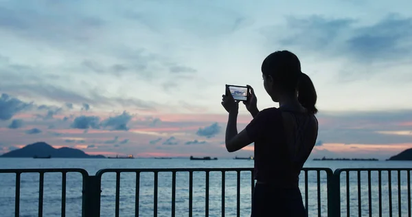 Kobieta Używa Telefonu Komórkowego Robienia Zdjęć Zachodzie Słońca — Zdjęcie stockowe
