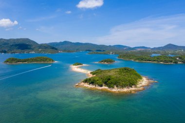 İnsansız hava aracı güzel adanın ve denizin üzerinde uçuyor.