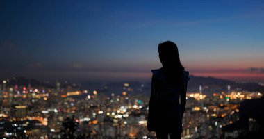 Kadınlar gün batımında şehir manzarasının tadını çıkarırlar.