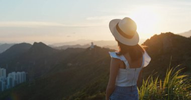 Kadınlar dağda gün batımının tadını çıkarırlar.
