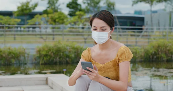 Vrouw Draagt Gezichtsmasker Het Gebruik Van Mobiele Telefoon Het Park — Stockfoto