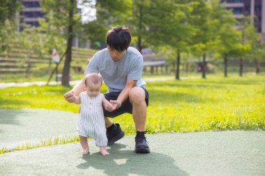 Father teaching son to walk for first time