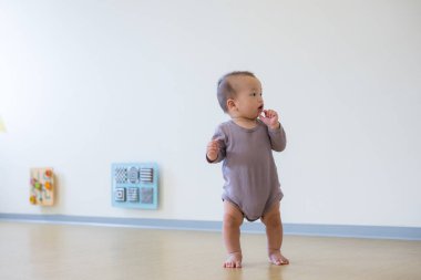 Little baby boy sitting alone inside playhouse