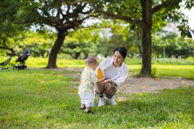 Mother play with son together at green park