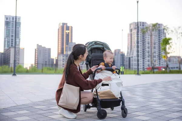 Mother talking to baby in stroller at outdoor