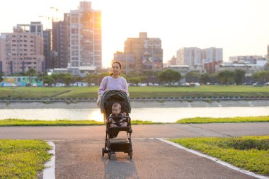 Park 'ta bebek arabasını iten kadın.