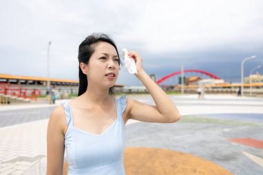 Woman feel so hot outside and use tissue