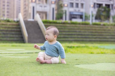 Little baby boy sit on the grass