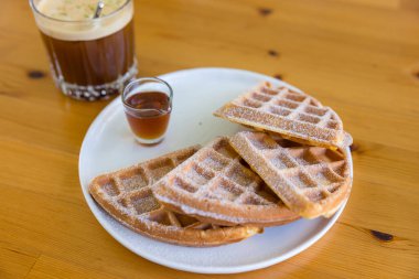 Baked waffle with syrup in coffee shop