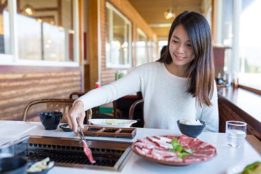 Woman enjoying meat barbecue at restaurant