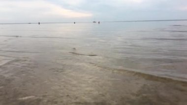 Letonya, Jurmala. Bir akşam ufukta bir yat fonuna karşı Baltık Denizi Riga Körfezi'nde yüzmek.