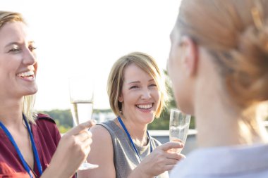 Gülümseyen genç iş arkadaşları çatıda başarı partisi zevk