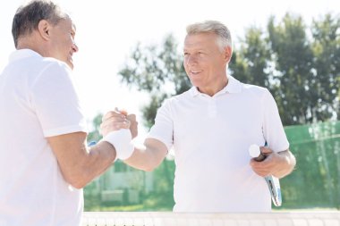 Güneşli maç sırasında Tenis Kortu dururken tebrik erkekler gülümseyen