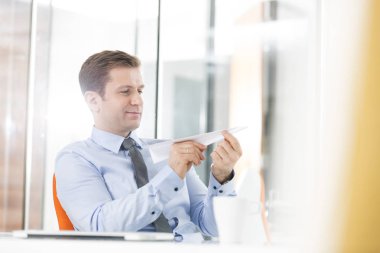 Ofiste otururken kağıt uçak holding yaratıcı iş adamı