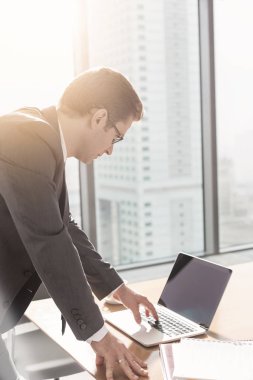 İşadamı yönetim kurulu odasında masada dizüstü bilgisayar kullanıyor