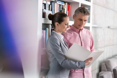 Daire ayakta iken erkek müşteri belge gösteren emin genç satış elemanı