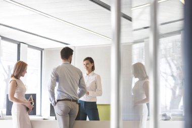 Ofiste bilgisayar masasında duran iş arkadaşları