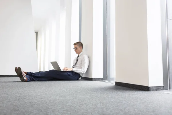 Junger Geschäftsmann Benutzt Laptop Während Büro Auf Dem Boden Sitzt — Stockfoto