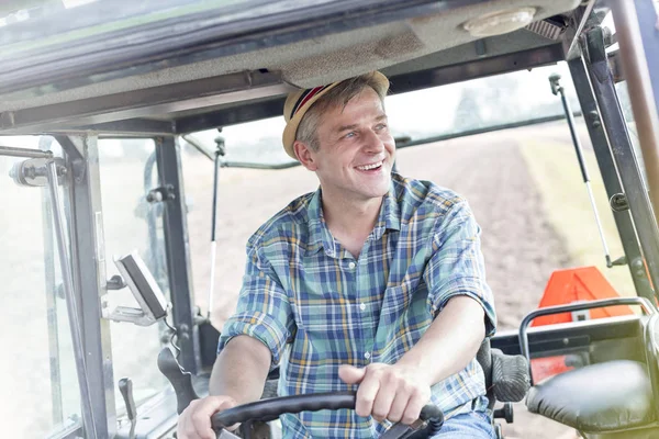微笑的自信的农夫驾驶拖拉机在农场 — 图库照片