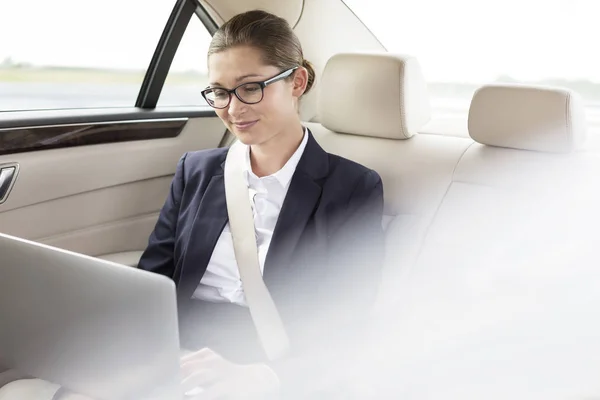 有吸引力的女商人在车上使用笔记本电脑 — 图库照片