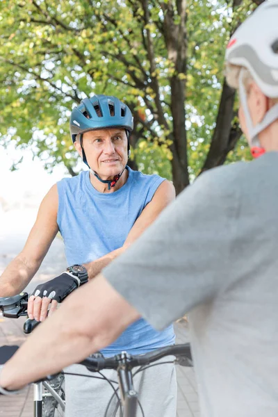 Senior man in sportswear talking to woman in park