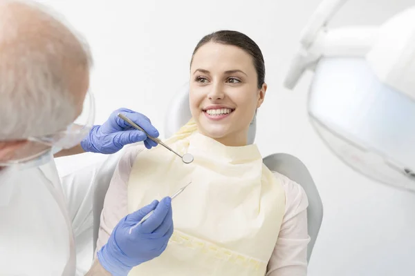 Odontólogo Senior Examinando Paciente Joven Con Equipo Dental Clínica — Foto de Stock