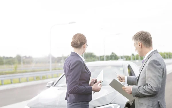 Försäkringsagent Diskuterar Med Affärskvinna Medan Pekar Uppdelning Bil Mot Himlen — Stockfoto