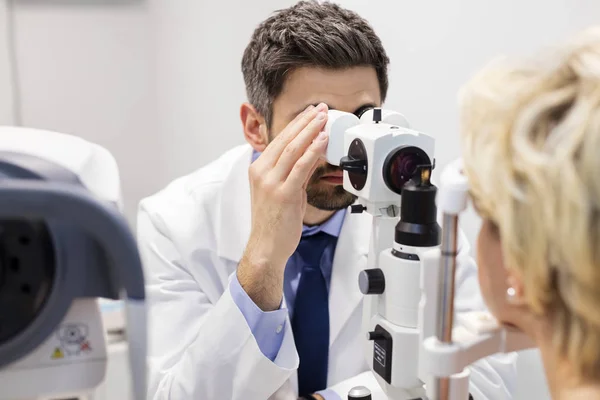 Mitte Erwachsener Arzt Untersucht Patientin Auf Phoropter Krankenhaus — Stockfoto