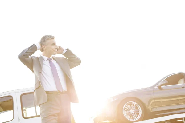 レッカー車の彼の車をピックアップしながらスマート フォンで話すビジネスマン — ストック写真