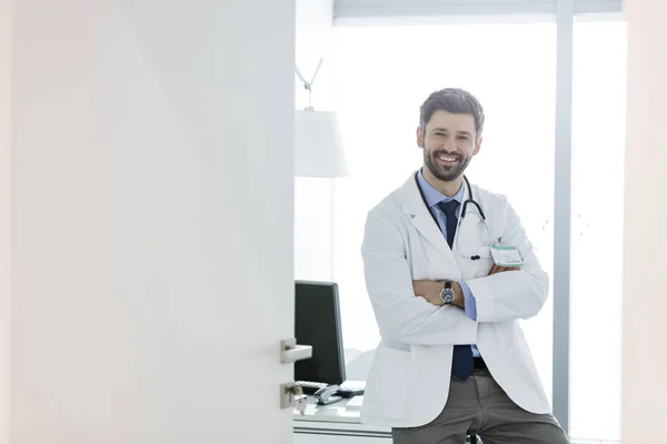 Retrato Del Médico Confiado Pie Con Los Brazos Cruzados Escritorio — Foto de Stock