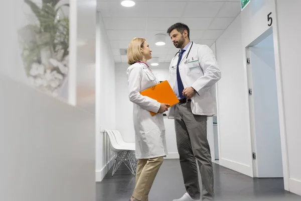 病院の廊下で議論する医師の低角度図 — ストック写真