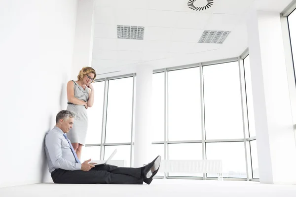 Businesswoman Standing Businessman Using Laptop New Office — Stock Photo, Image