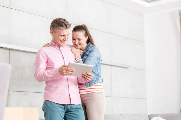Casal Sorridente Usando Tablet Digital Enquanto Estava Contra Parede Apartamento — Fotografia de Stock