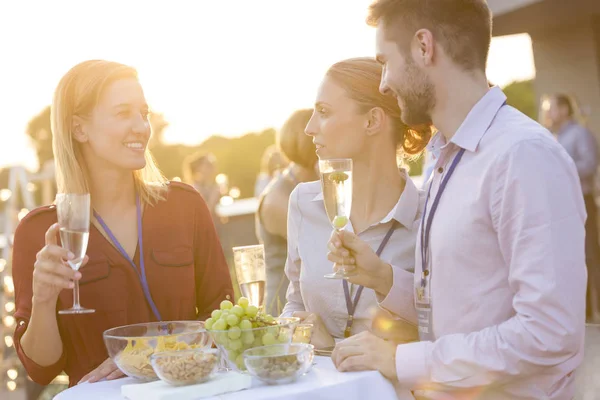 Lächelnde Junge Kollegen Gespräch Mit Weingläsern Bei Erfolgsfeier Auf Dem — Stockfoto