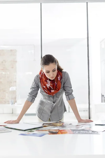 Businesswoman Analyzing Photographs While Leaning Desk — Stock Photo, Image