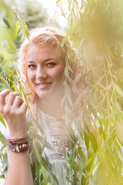 Parkta Yaprakların Arasında Duran Gülümseyen Güzel Genç Kadının Portresi — Stok fotoğraf