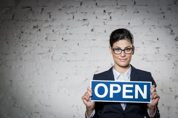 Portrait Beautiful Young Businesswoman Holding Open Sign Placard Brick Wall — Stock Photo, Image