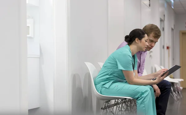 Hastanede Koridorda Otururken Genç Hastaya Tıbbi Form Açıklayan Hemşire — Stok fotoğraf