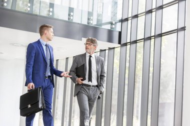 İş adamları ofiste yürürken tartışıyorlar