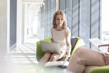 Meslektaşım office dosyası okunurken dizüstü kullanarak iş kadını