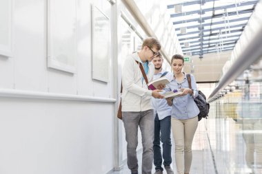 Öğrenciler College koridorda yürürken kitap alışverişi