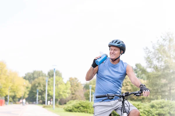 Adatto All Uomo Anziano Acqua Potabile Mentre Bicicletta Nel Parco — Foto Stock