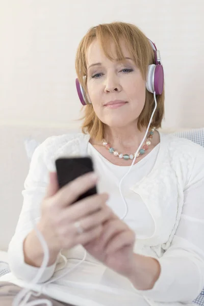 Donna Matura Utilizzando Smartphone Mentre Seduto Casa — Foto Stock